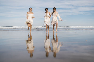 Carefree young women running together at beach