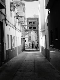 Rear view of woman walking on walkway in city