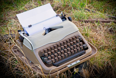 Close-up of typewriter on grassy field