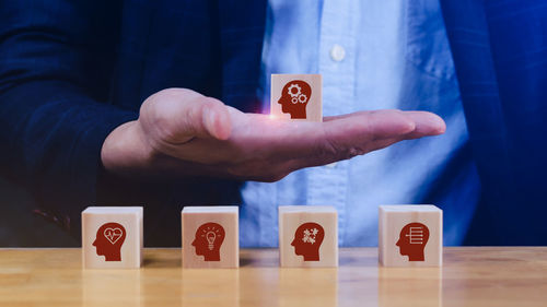 Midsection of businessman with toy blocks on table