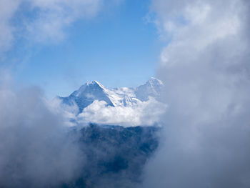 Low angle view of snowcapped mountains against sky