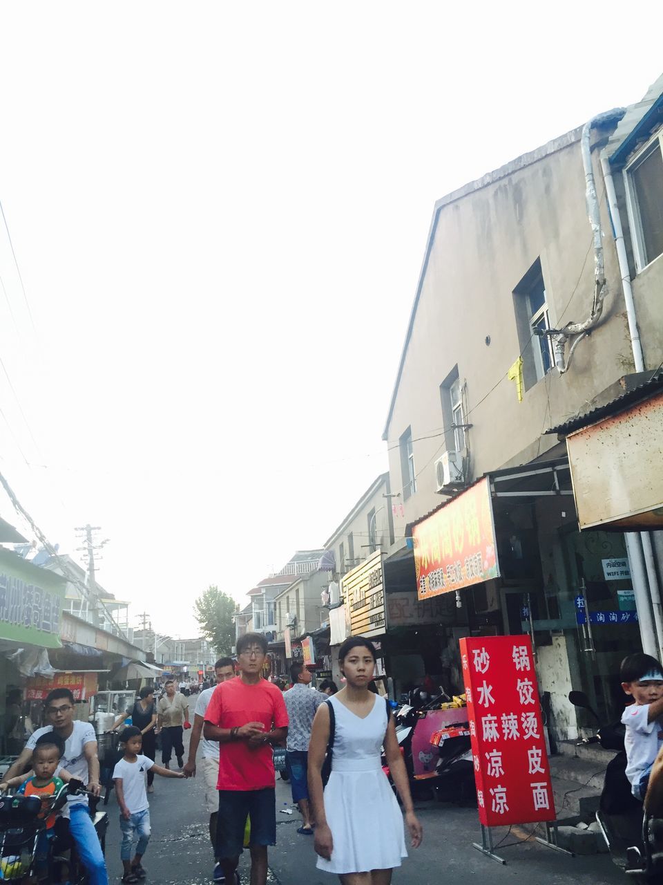 large group of people, person, clear sky, men, building exterior, city, group of people, architecture, city life, casual clothing, sky, day, crowd