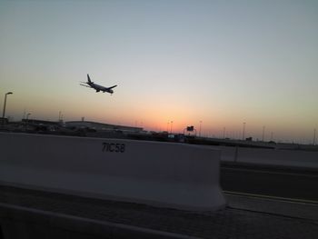 Airplane wing in sky during sunset