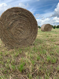 Hay bales on field against sky