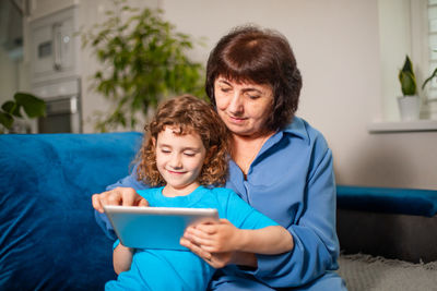 Boy sitting on mobile phone at home