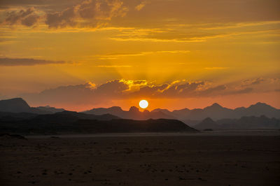 Scenic view of silhouette mountains against sky during sunset