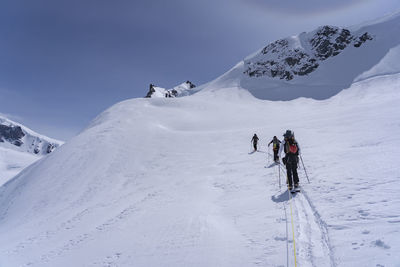 Rear view of people walking on snow covered land