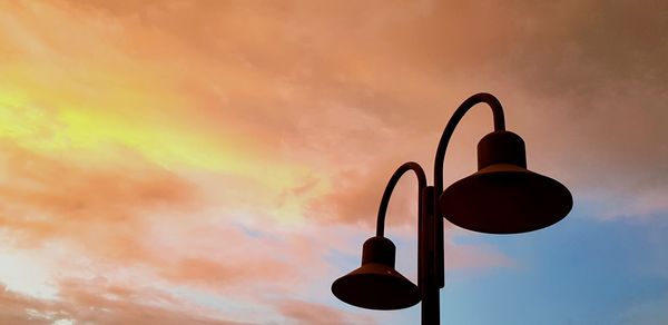 Low angle view of street light against orange sky