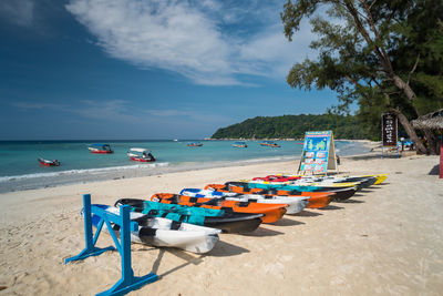 Boats moored at beach against sky