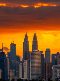 Buildings in city against sky during sunset