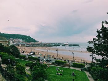 Scenic view of town by sea against sky