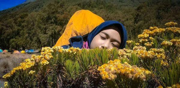 Rear view of woman by sunflower on field