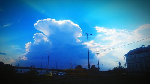 Low angle view of silhouette street against blue sky