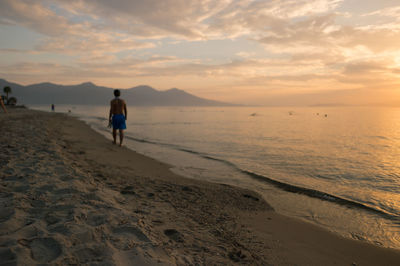 Rear view of man walking on beach