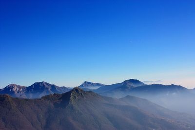 Scenic view of mountains against clear blue sky