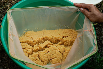 High angle view of hand holding bread in bowl