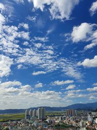 Aerial view of city against cloudy sky