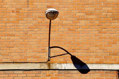 Lamp post on brick wall