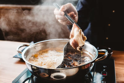 Midsection of man preparing food in kitchen