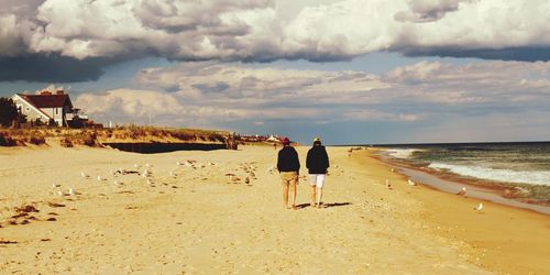 Scenic view of beach against cloudy sky