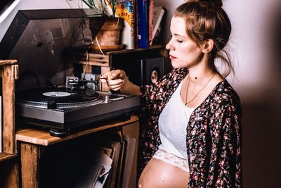 Young woman listening music while sitting at home