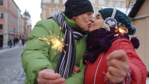 Midsection of man and woman in city during winter