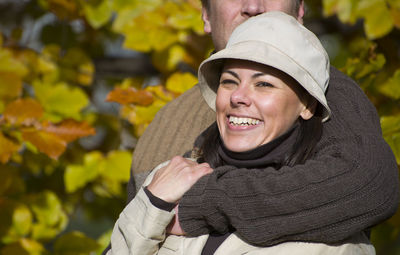 Close-up of smiling woman standing against trees