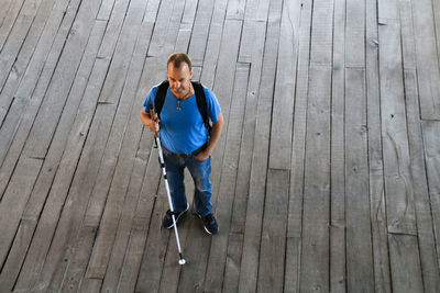 High angle portrait of man standing on wooden floor