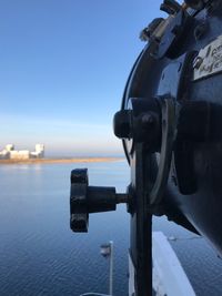 Close-up of coin-operated binoculars against sea