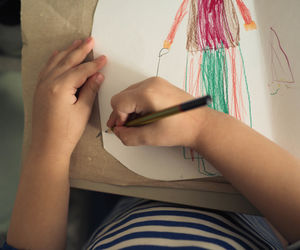 High angle view of girl drawing on paper