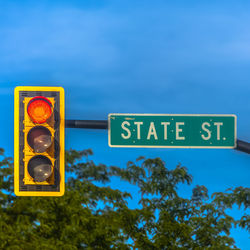 Low angle view of information sign against blue sky