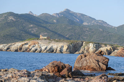 Scenic view of sea and mountains against clear sky