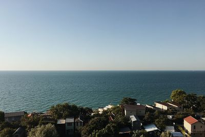 High angle view of townscape by sea against clear sky