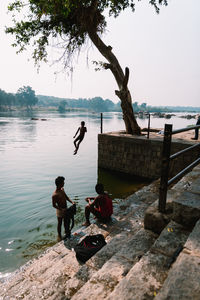 People at river against sky