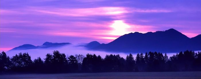 Scenic view of silhouette mountains against sky at sunset