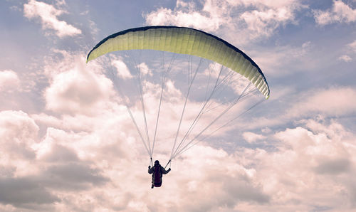 Low angle view of person paragliding against sky