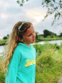 Portrait of smiling girl standing against sky