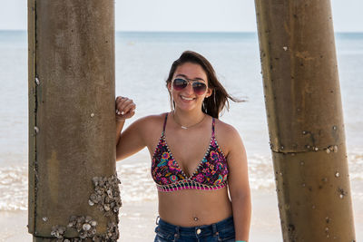 Woman standing below pier at beach