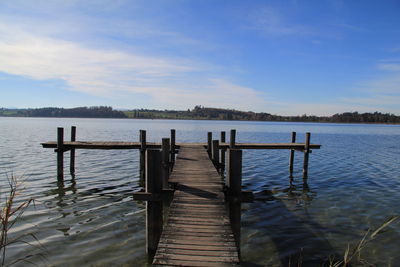 Wooden pier on lake against sky