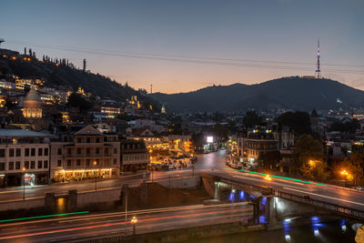 Illuminated city against sky at night