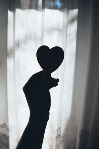 Silhouette person against window