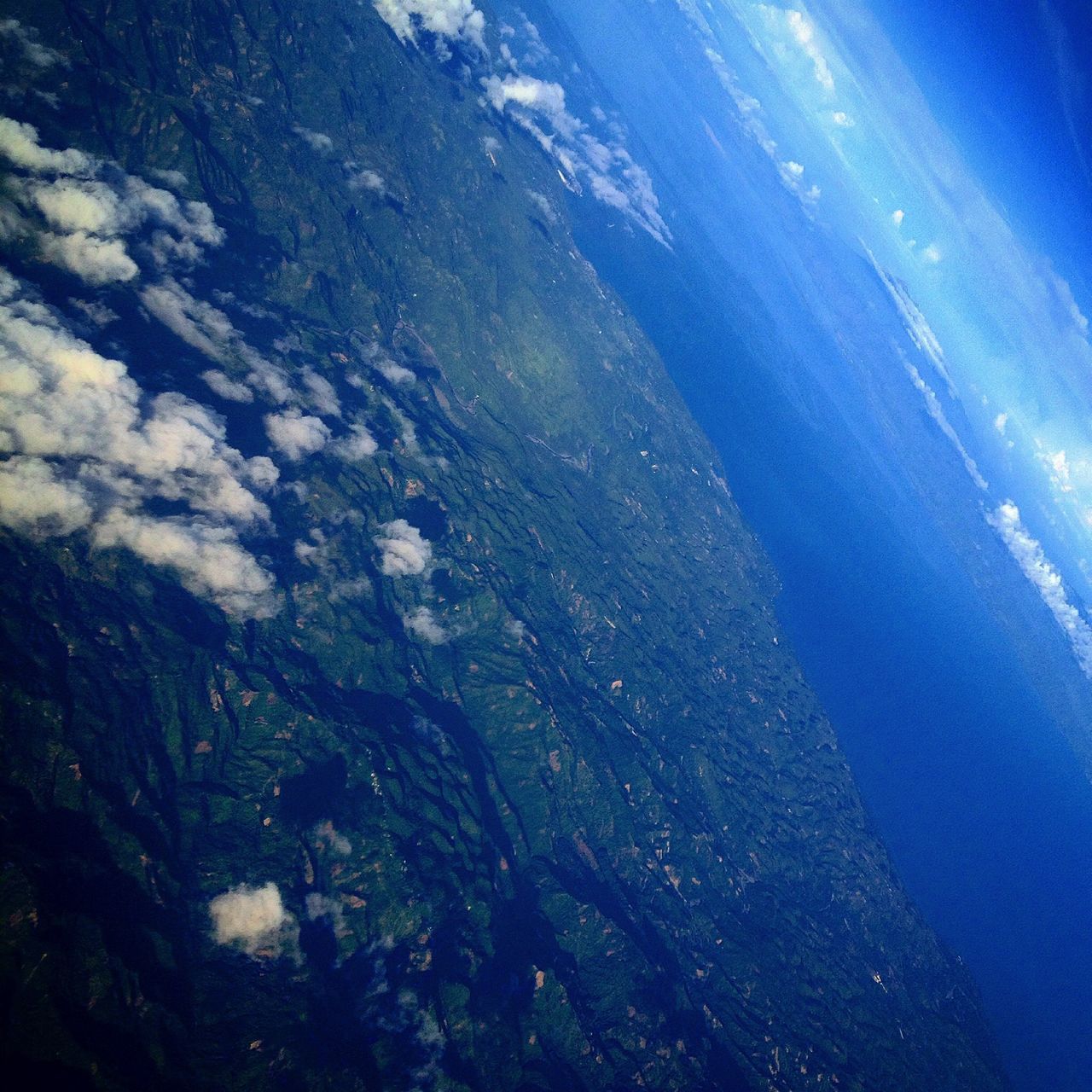 blue, beauty in nature, tranquility, scenics, nature, tranquil scene, aerial view, high angle view, water, sea, idyllic, sky, day, outdoors, sunlight, no people, non-urban scene, mountain, cloud - sky, landscape