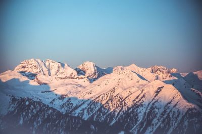 Scenic view of snowcapped mountains against clear blue sky