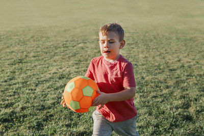 Boy holding soccer ball at park