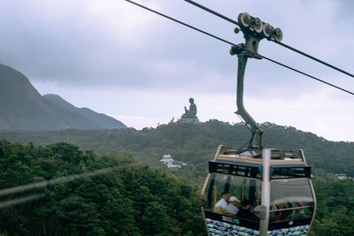 Overhead cable car on mountains against sky