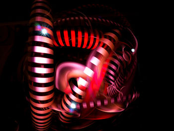 Close-up of illuminated lighting equipment against black background