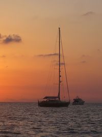 Boat sailing in sea at sunset