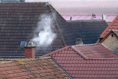Roofs of an old village with a smoking chimney and copyspace