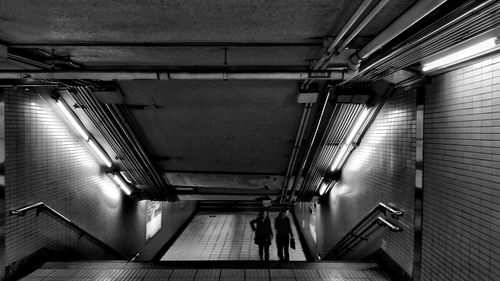 People walking on steps at illuminated subway station
