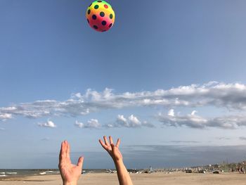 Low angle view of hand against blue sky